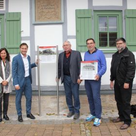  – BM Björn Steinbach und BM a.D. Harry Murso enthüllen die erste Tafel an der Eichelberger Kelter. Daneben Ortsvorsteherin Pamela Grimm-Baumann, Steffen Kappes (2.v.r.) und Thomas Kugler, Mitglieder der Arbeitsgruppe. Foto: Gemeinde Obersulm