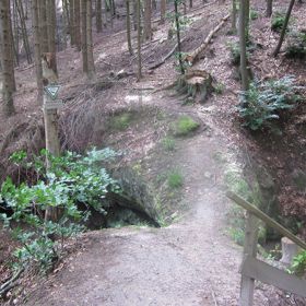 Felsenbrücke Hohlenstein mit Schild „Naturdenkmal“ – Die Felsenbrücke Hohlenstein stellt ein natürliches Gebilde aus Stubensandstein auf der Gemarkung Eichelberg dar. Der Fels hat eine Länge von ca. 8 Metern und ist ca. 3-4 Meter hoch. Er ist in der Mitte unterhöhlt und als Durchgang begehbar. Die Felsenbrücke Hohlenstein ist als Einzelschöpfung der Natur zur Erhaltung einer natürlichen Felsenbrücke im Stubensandstein wegen ihrer Eigenart und Seltenheit unter Schutz gestellt. Geschützt ist die komplette Waldklinge ober- und unterhalb der Felsenbrücke auf jeweils 25 m Länge.